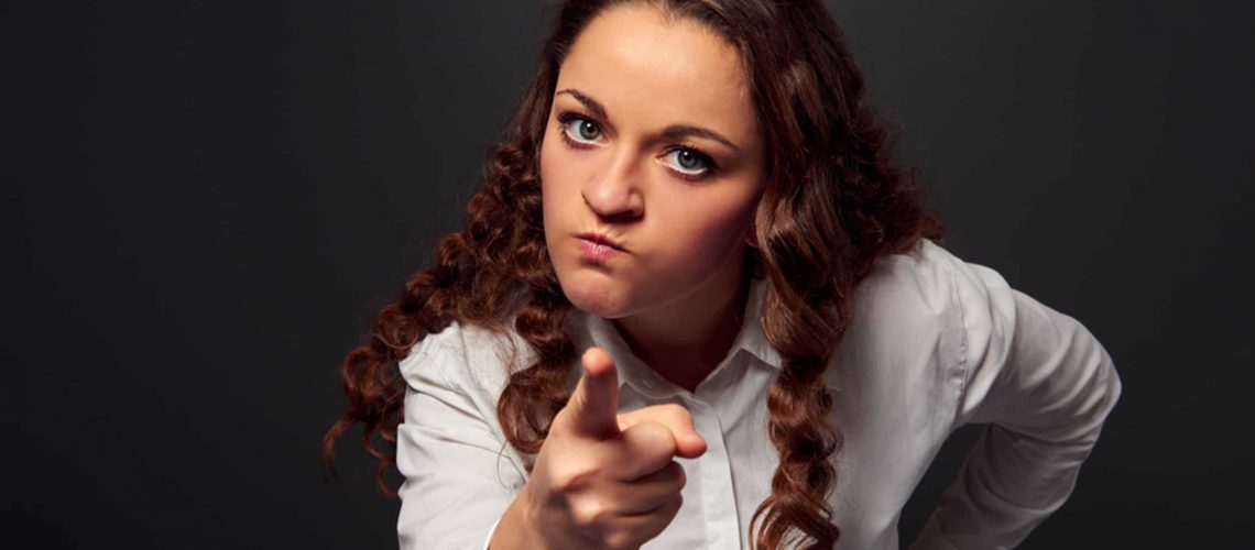 studio shot of angry woman pointing at camera. picture over dark background; Shutterstock ID 127729037; PO: today.com TPT